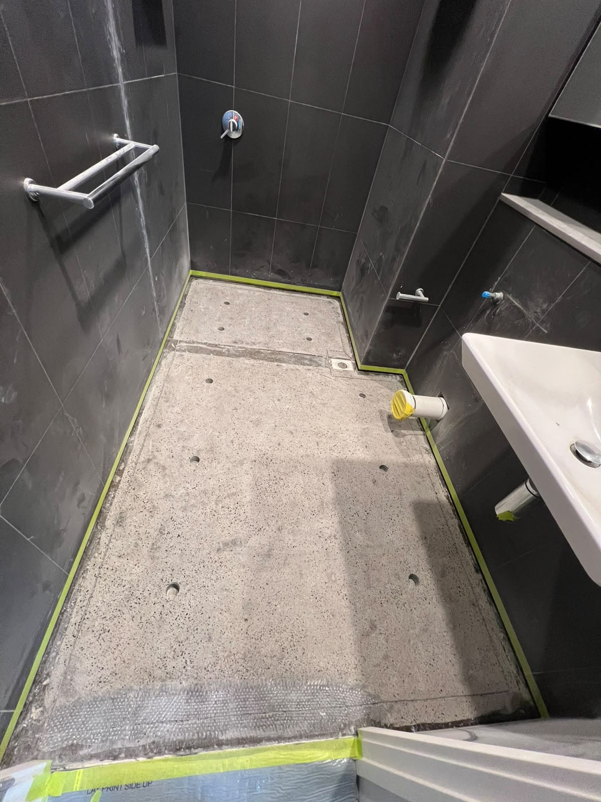 Bathroom concrete floor substrate ground and taped prior to waterproofing — Melbourne
