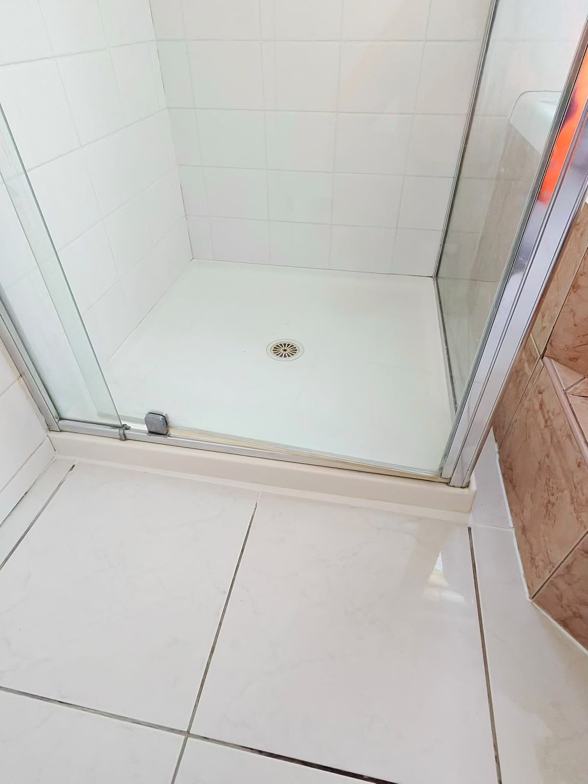 Finished white shower recess with fresh grout lines and sanitary silicone joints — Melbourne