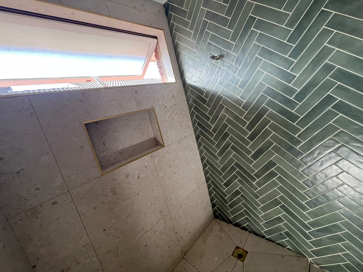 Full-height bathroom wall tiling with green herringbone feature wall — Melbourne