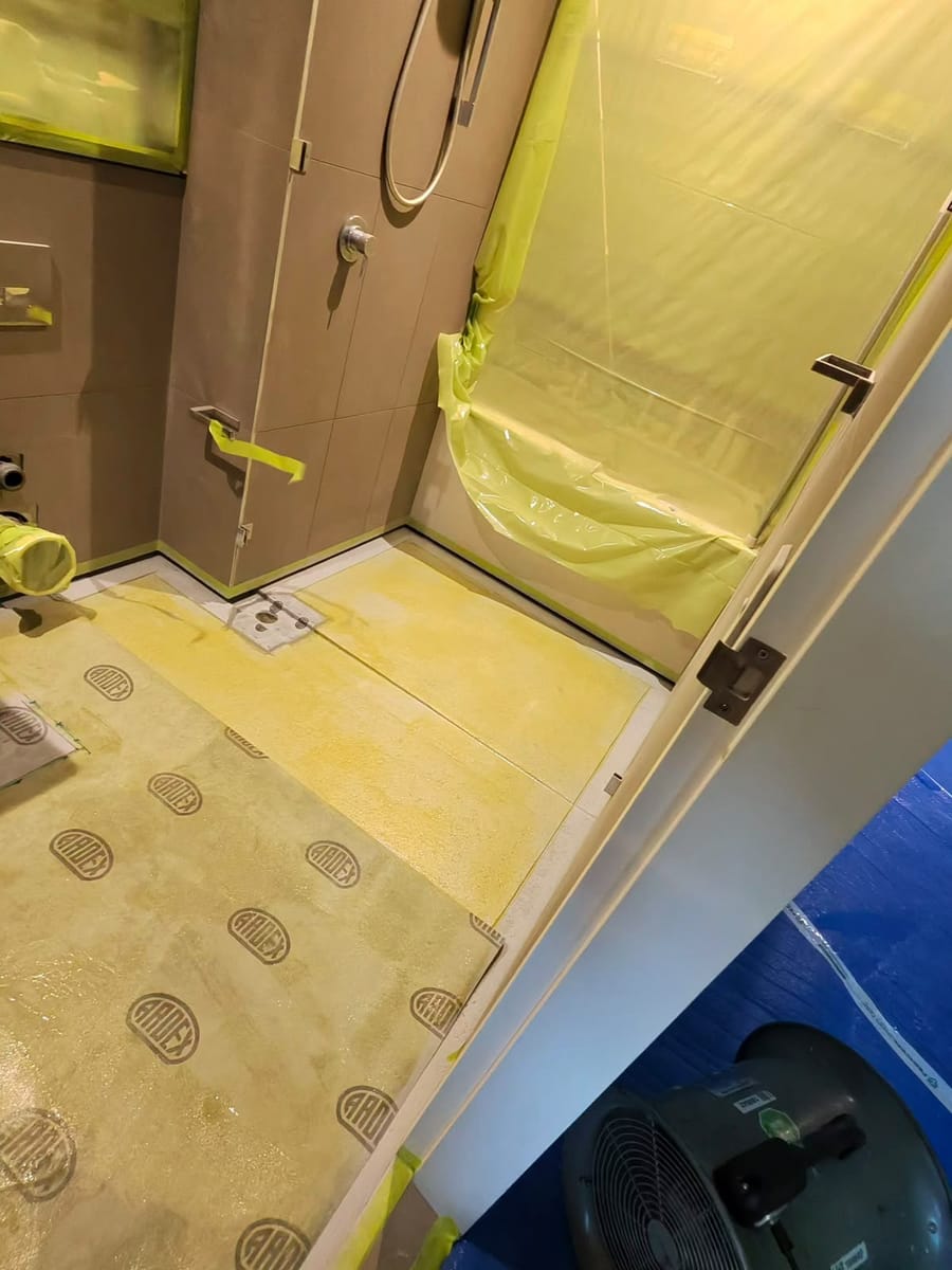 Clean cured epoxy grout joints on shower floor with sponge maintenance
