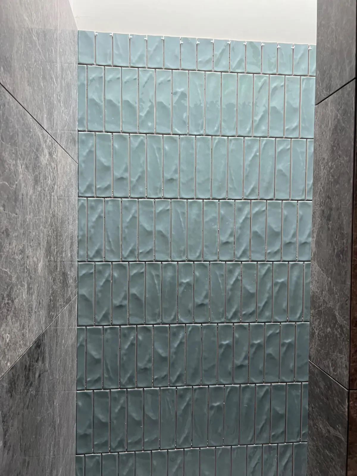 Vertical fluted sage green subway feature wall tiles framed by natural stone — Melbourne