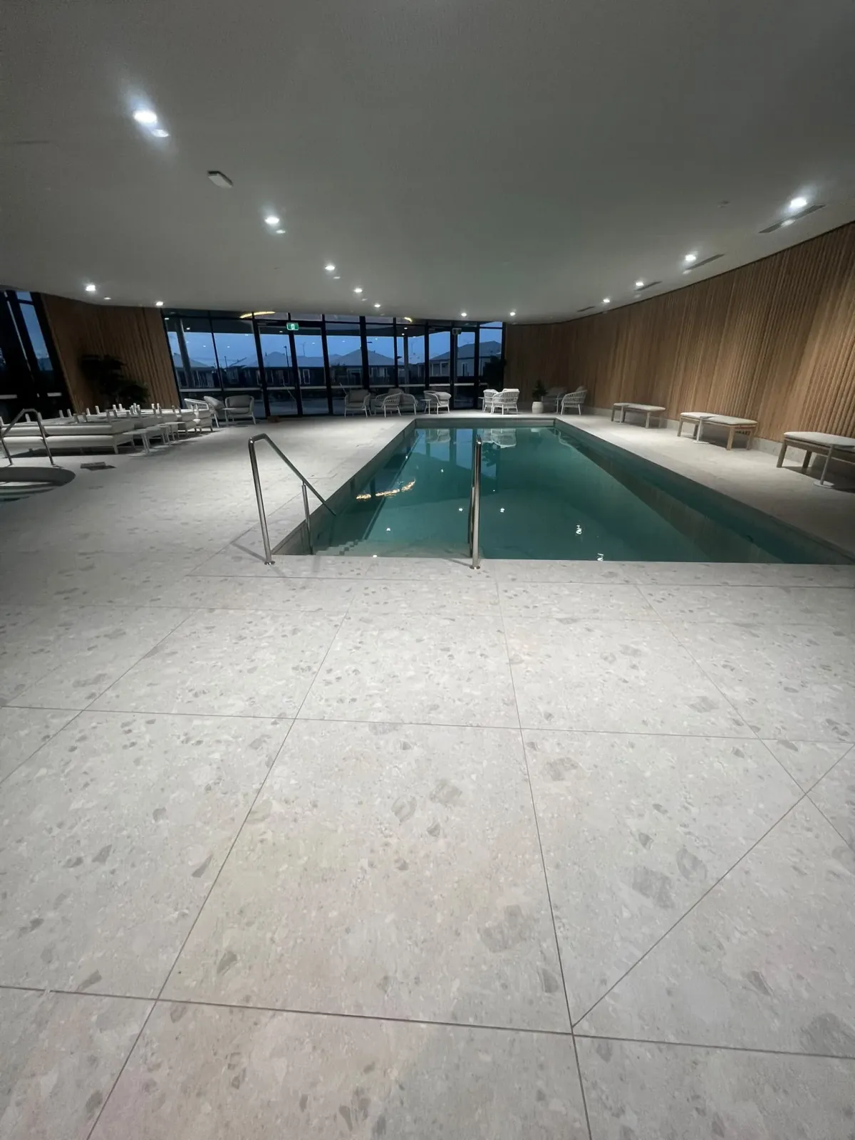 Completed large-format terrazzo pool surround tiling and sealed coping joints — Melbourne