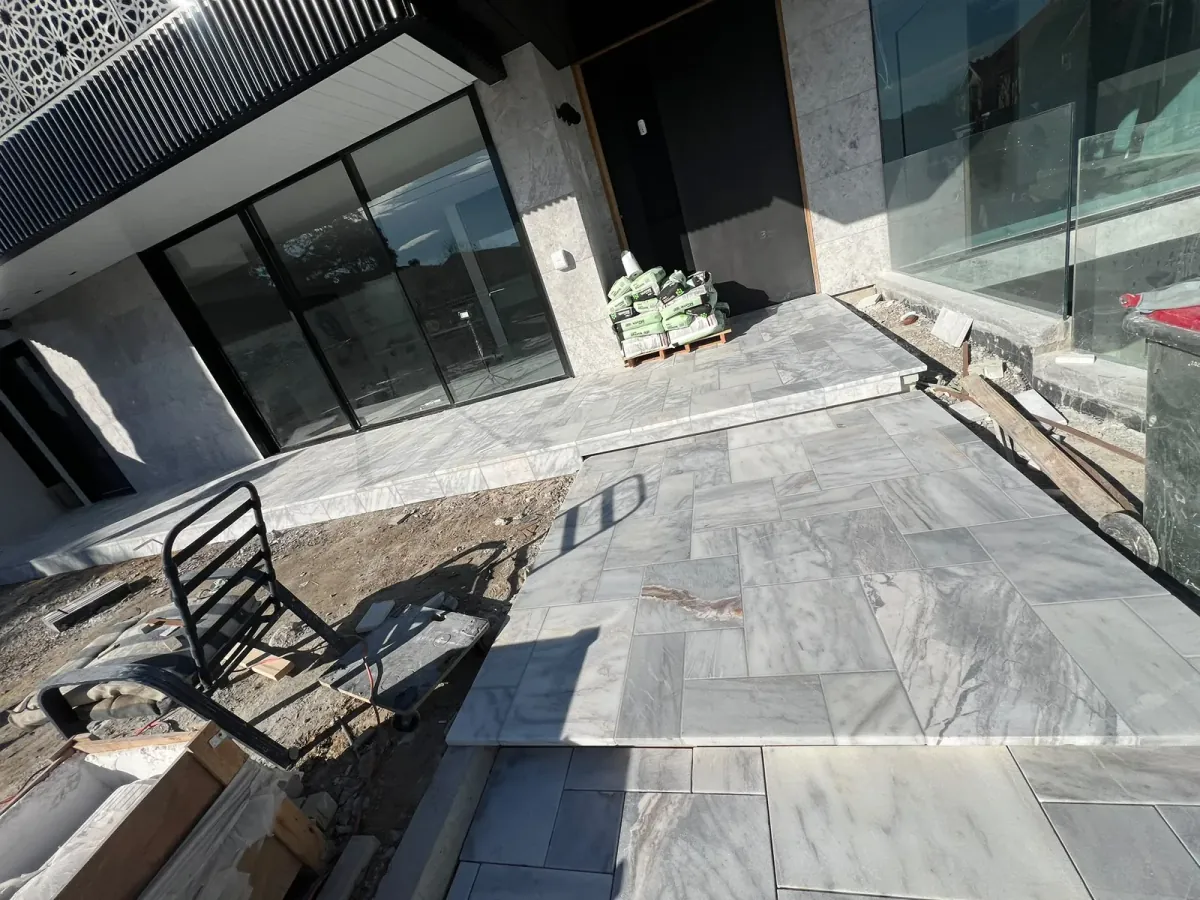 External entrance landing and ramp paved with solid-bed natural stone tiles