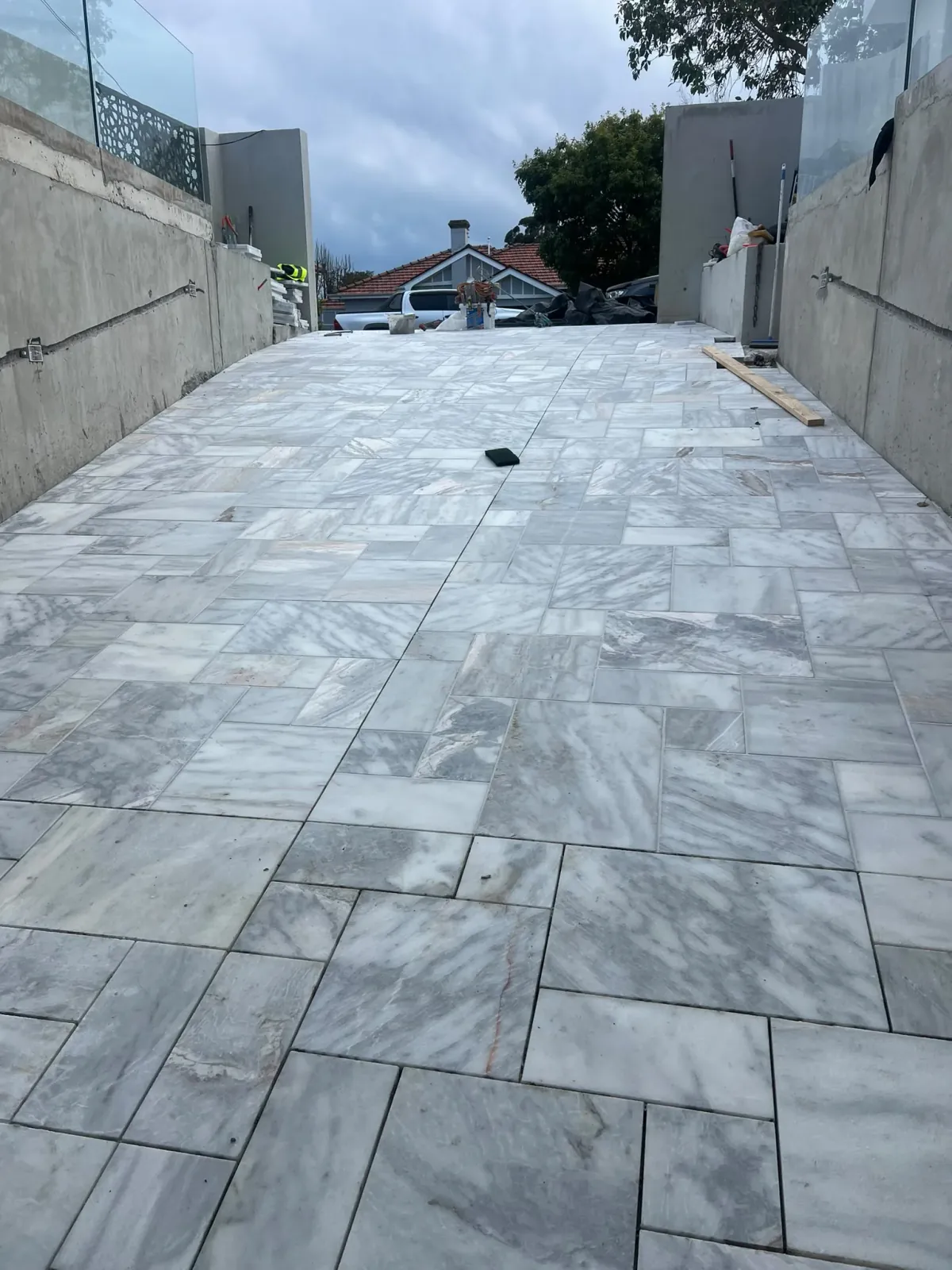 Natural stone travertine pavers installed on outdoor driveway and patio with expansion joint — Melbourne