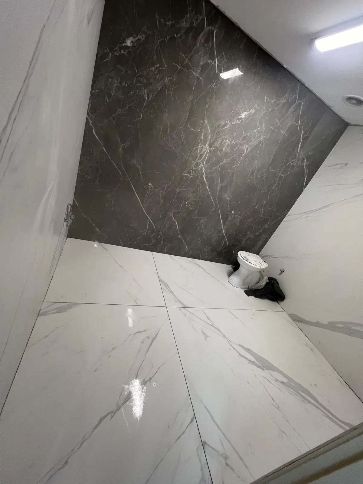 Large-format Statuario white porcelain tiles paired with dark Grigio feature wall — Melbourne