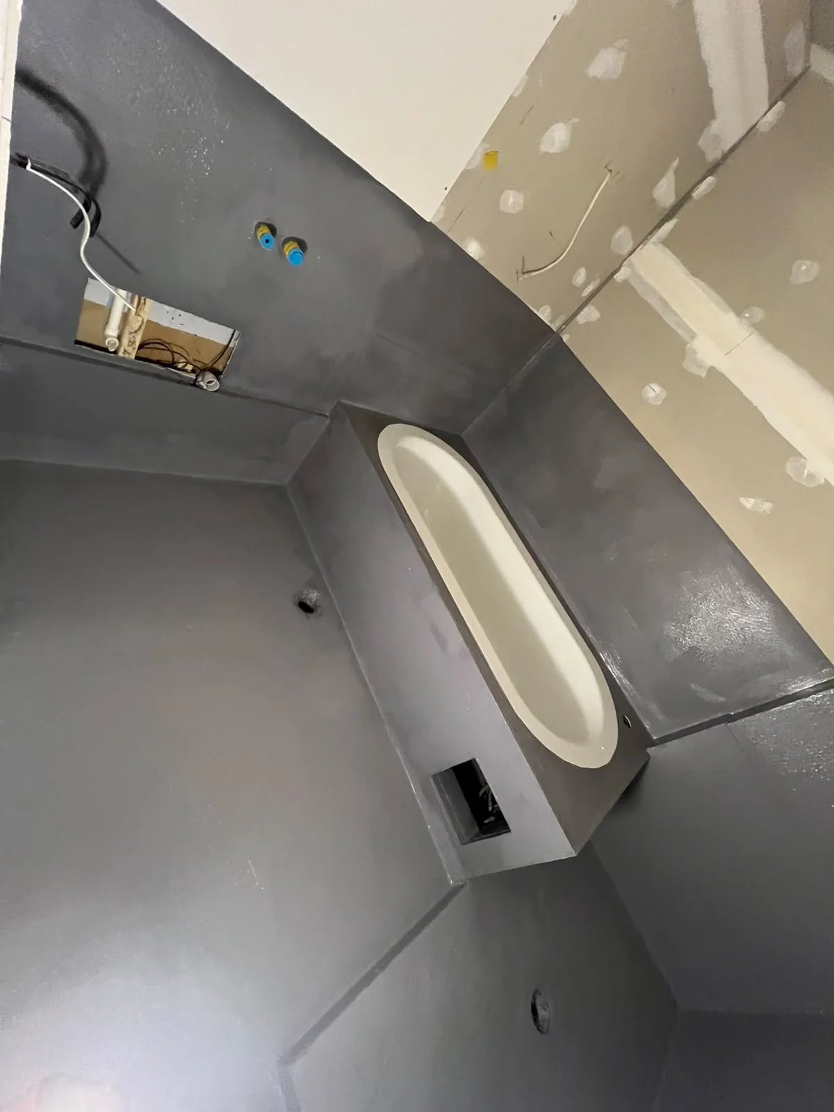 Class III waterproofing membrane applied across wet room floor and shower walls